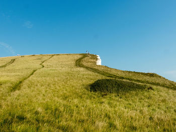 Built structure on field against clear blue sky