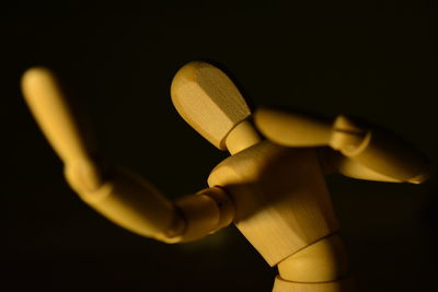 Close-up of wooden figurine against black background