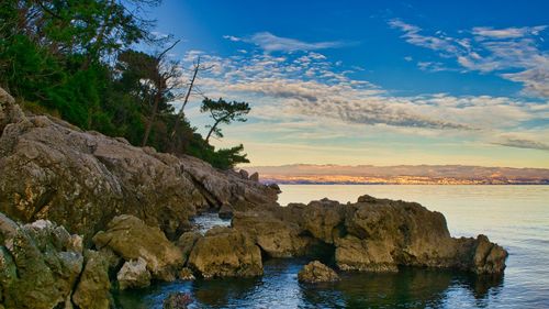 Scenic view of rocks in sea against sky