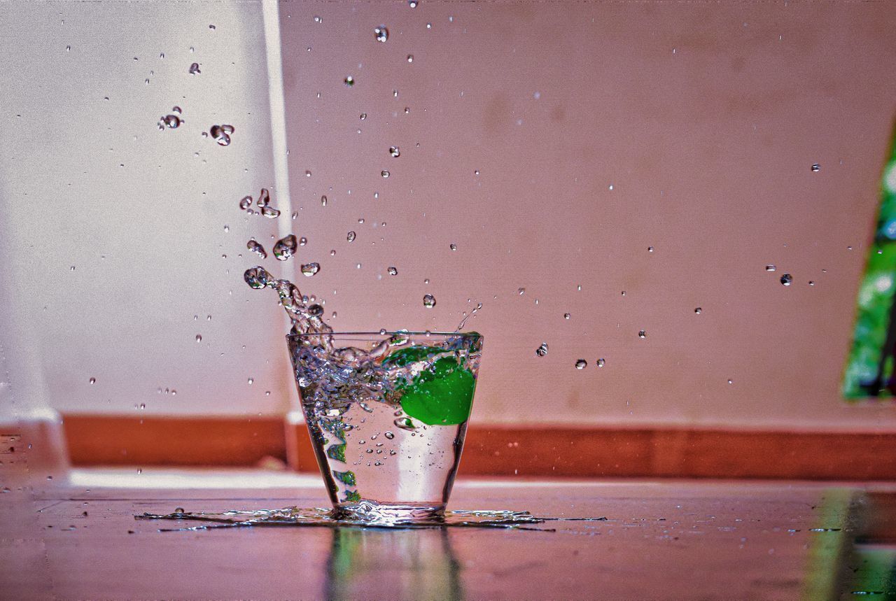 CLOSE-UP OF WATER SPLASHING IN GLASS