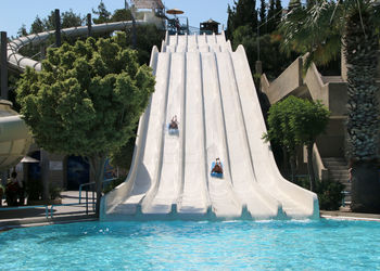 View of swimming pool by trees against sky