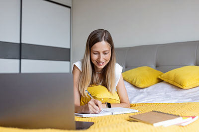 Portrait of young woman using laptop at home