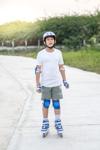 Full length portrait boy inline skating on road