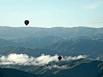 Kite flying over mountains against sky