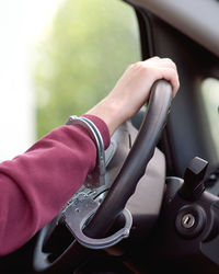 Cropped hand of man driving car