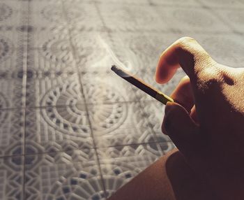 Close-up of hand holding cigarette