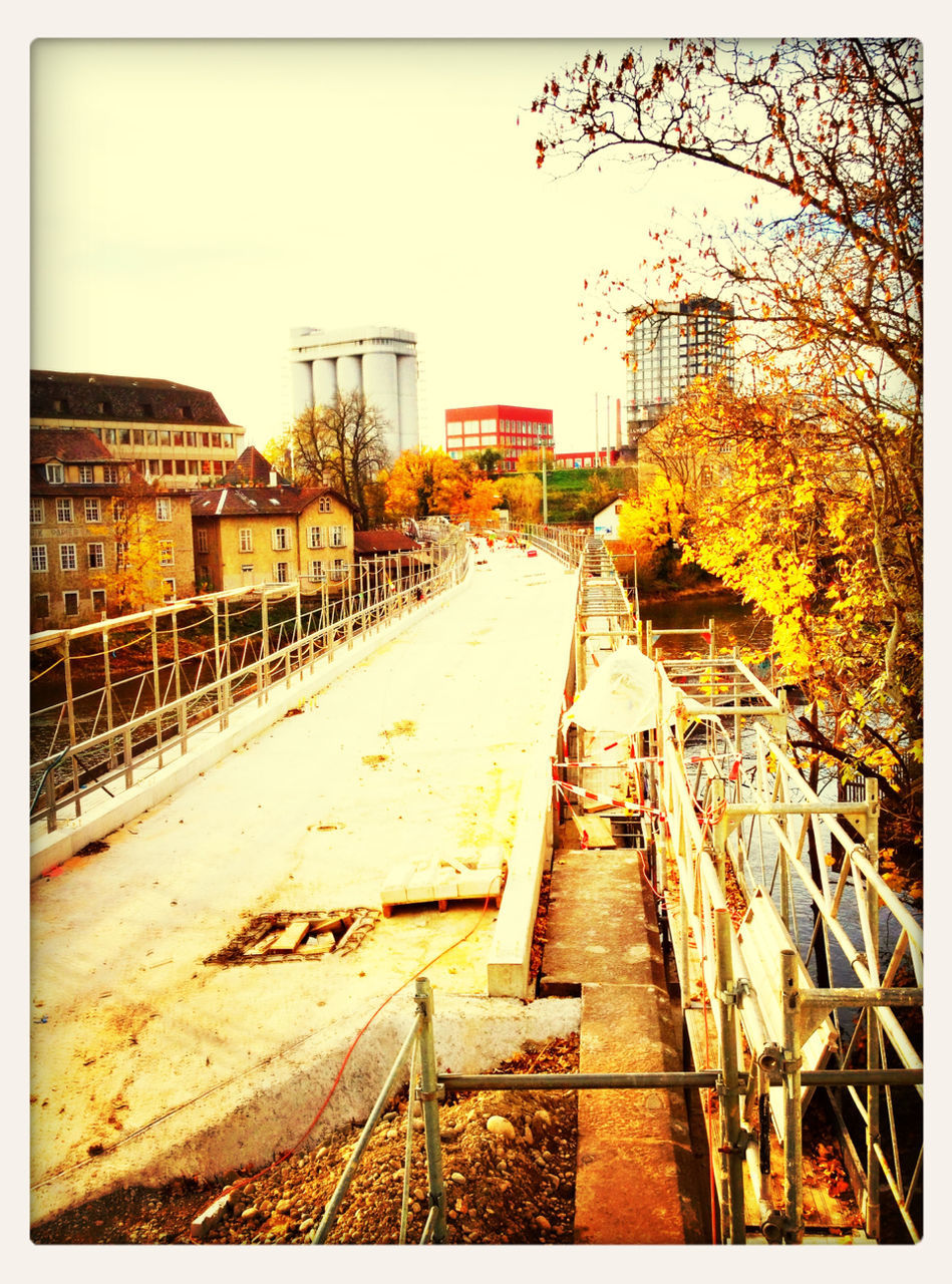 transfer print, architecture, built structure, building exterior, auto post production filter, railing, clear sky, railroad track, house, day, outdoors, the way forward, metal, city, sky, residential building, residential structure, no people, building, diminishing perspective