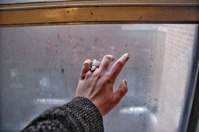 Cropped hand touching window