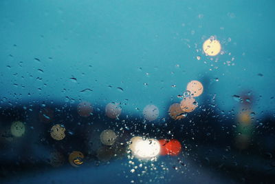 Illuminated lights seen through wet car window