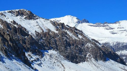 Scenic view of snowcapped mountains against clear blue sky