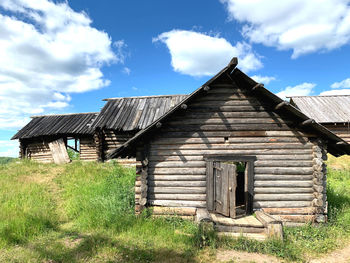 Old house on field against sky