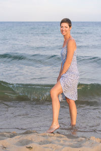 Portrait of young woman standing at beach