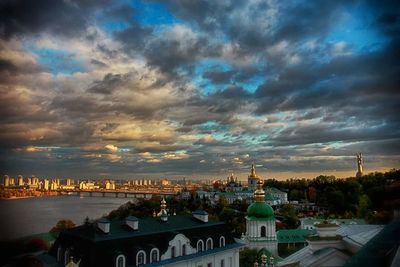 Buildings in town against cloudy sky