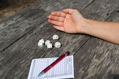 High angle view of hand holding coins on table