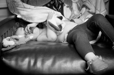 Low section of people relaxing on bed at home