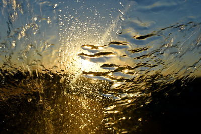 Close-up of water against sky during sunset