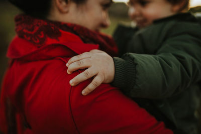 Midsection of mother and daughter in warm clothing outdoors