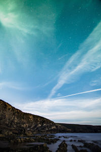 Low angle view of snowcapped mountain against blue sky