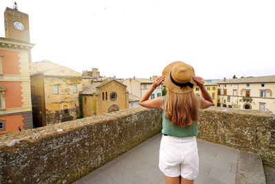 Traveler girl enjoying townscape of orvieto from a terrace of historic palace, orvieto, umbria,italy