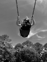 Low angle view of swing ride against sky