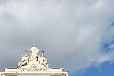 Low angle view of sculpture against cloudy sky