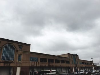 Low angle view of buildings against cloudy sky