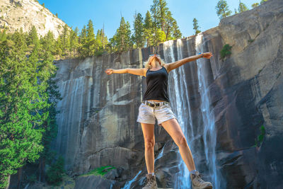 Rear view of senior woman against waterfall