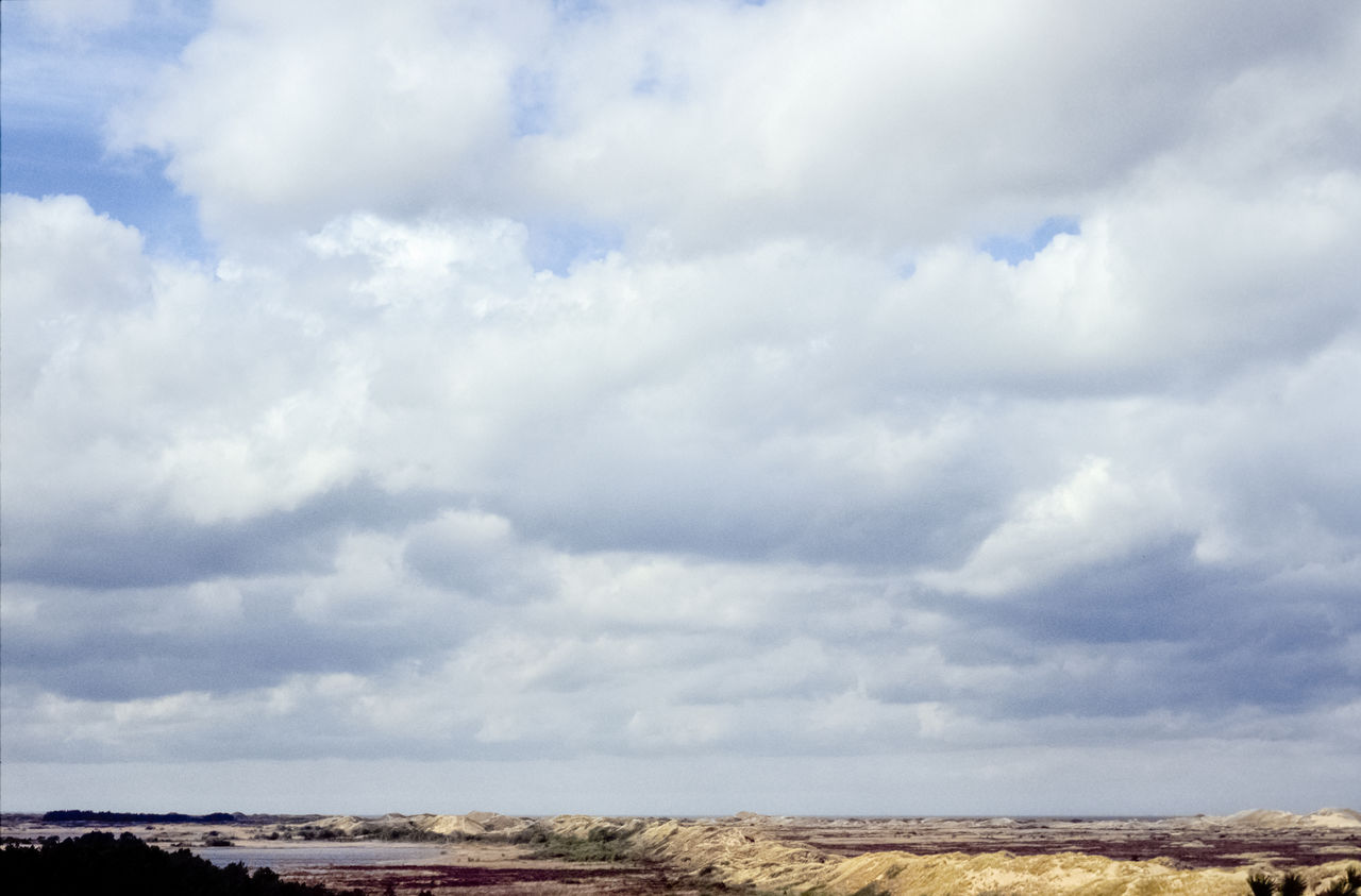 cloud, sky, horizon, environment, landscape, nature, sea, scenics - nature, land, no people, beauty in nature, day, travel destinations, hill, cloudscape, outdoors, travel, non-urban scene, rural area, coast, tranquility, field, tourism, tranquil scene, blue, plain, water, overcast, semi-arid, horizon over land, architecture, copy space, rock