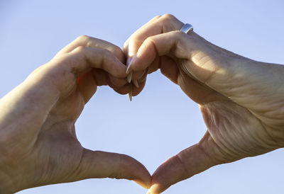 Low angle view of heart shape against clear sky