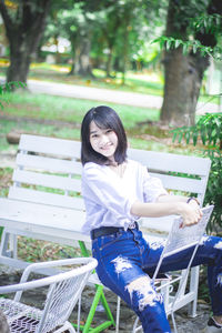 Portrait of young woman sitting on bench