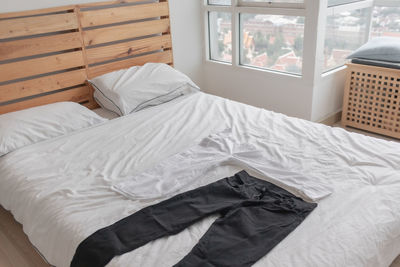 Midsection of person relaxing on bed at home