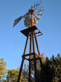 Low angle view of traditional windmill against clear blue sky