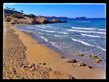 Scenic view of beach against blue sky