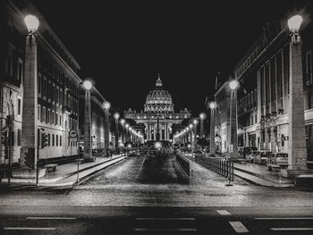 Illuminated city street and buildings at night