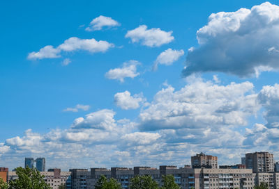 Buildings in city against cloudy sky