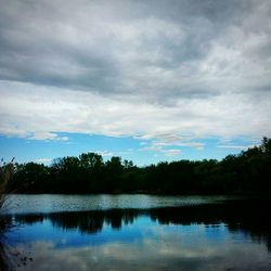 Scenic view of lake by trees against sky