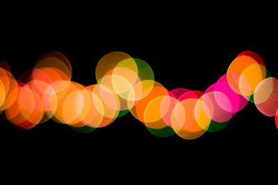 Defocused image of colorful lights against black background