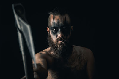 Portrait of shirtless man against black background