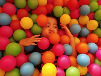 High angle view of girl amidst multi colored balls