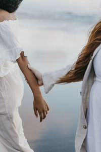 Rear view of couple kissing against sea