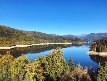 Scenic view of lake against clear blue sky