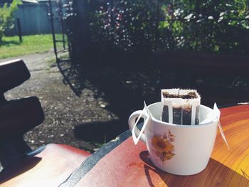 Close-up of coffee cup on table during sunny day