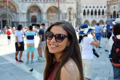 Smiling woman wearing sunglasses standing at st mark square