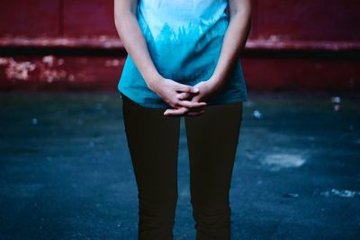 Low section of woman standing against blurred background