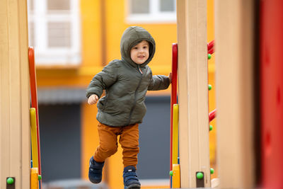 Cute happy toddler boy three years old is playing on the playground in a residential complex. 