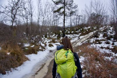 Rear view of woman standing on snow covered landscape