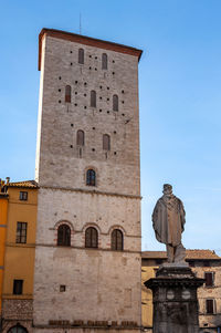 Low angle view of statue against historic building