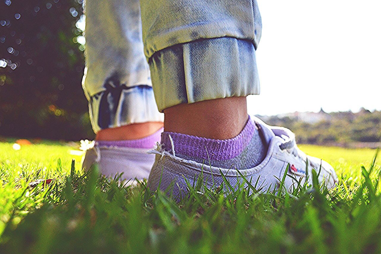 grass, field, relaxation, lifestyles, day, leisure activity, close-up, grassy, outdoors, blue, part of, nature, growth, casual clothing, focus on foreground, green color, landscape