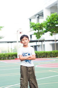 Portrait of boy standing at baskball court