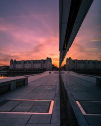 Bridge in city against sky during sunset